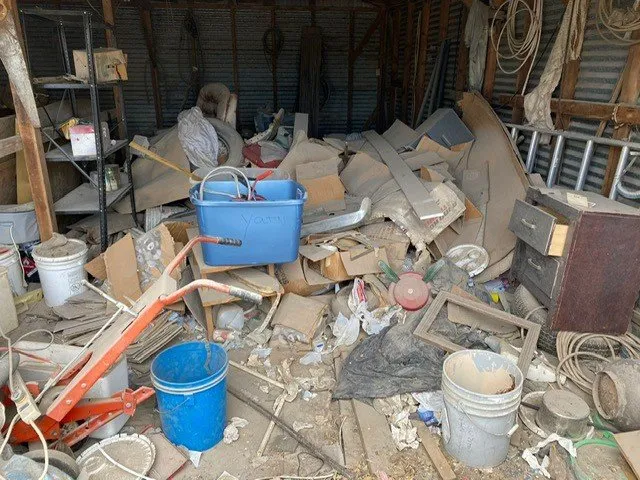 A cluttered storage space filled with various discarded items and debris.