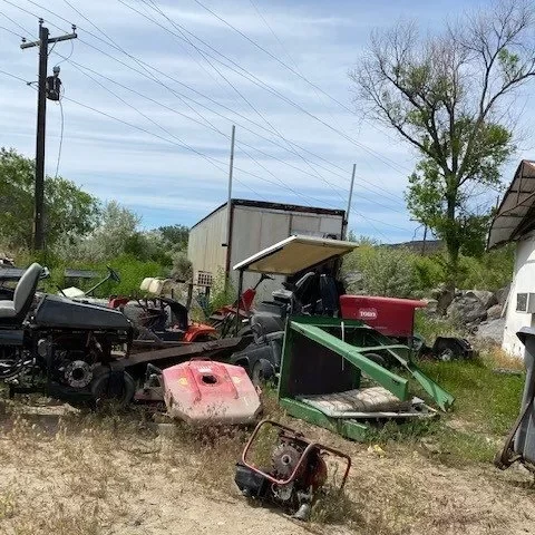 An assortment of discarded equipment and machinery in a cluttered outdoor space.